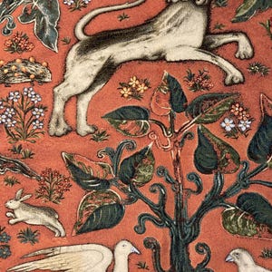 May include: A tapestry featuring a white lion with a red flame coming out of its mouth, surrounded by green leaves and flowers on a red background.