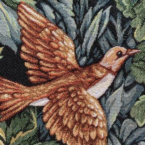 May include: A tapestry featuring a brown and white bird with a long beak, perched on a bed of green and blue leaves.