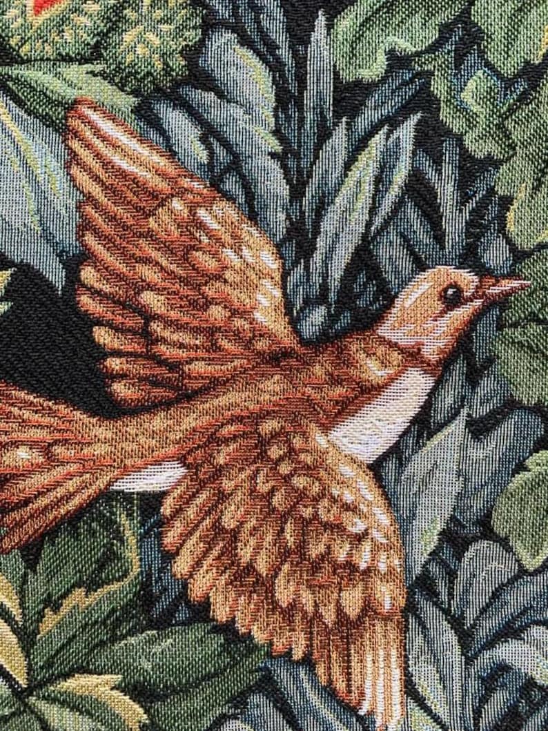 May include: A tapestry featuring a brown and white bird with a long beak, perched on a bed of green and blue leaves.