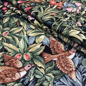 May include: A tapestry fabric with a dark background featuring a brown deer, birds, and green foliage.