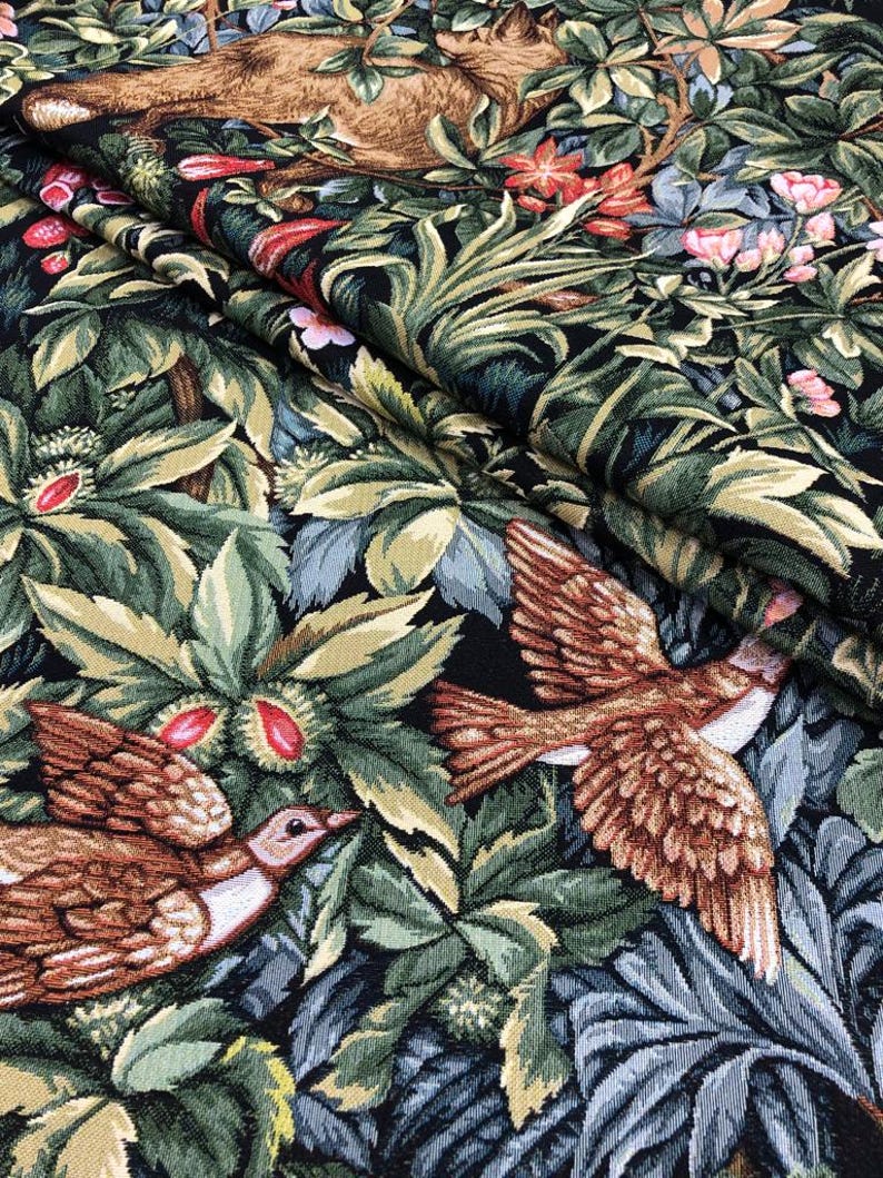 May include: A tapestry fabric with a dark background featuring a brown deer, birds, and green foliage.