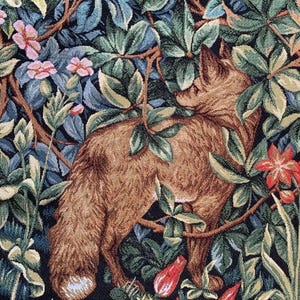May include: A tapestry featuring a brown fox standing in a lush green forest with red and pink flowers. The fox is surrounded by leaves and branches, creating a sense of depth and detail.