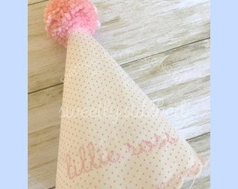 Può includere: Cappello da festa rosa chiaro con un grande pompon rosa. Il cappello è bianco a pois rosa e il nome "lillie rose" è ricamato in rosa. Il bordo inferiore ha un bordo smerlato.
