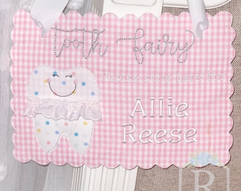 May include: Pink and white gingham tooth fairy door with a white tooth with a smiling face and colorful polka dots. The text reads "Tooth Fairy Please stop here for Allie Reese".