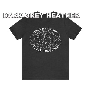 K&ouml;nnte beinhalten: Dunkelgraues T-Shirt aus Heather-Material mit einem wei&szlig;en Motiv von H&uuml;hnern und dem Text "Birds of a feather flock together".