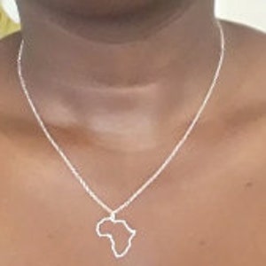 May include: A silver necklace with a pendant shaped like the outline of the continent of Africa.