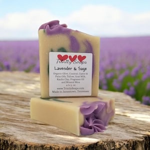 May include: A bar of lavender and sage soap with a purple and white swirl design. The soap is made with organic olive, coconut, castor and palm oils, tallow, goat milk, kaolin clay, fragrance oil and mineral mica. The soap is 4 to 5 ounces and is made in Jamestown, Tennessee.