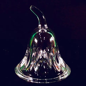 May include: A clear glass bell with a green stem. The bell has a scalloped edge and a textured surface.