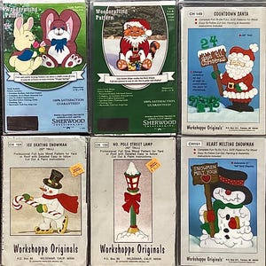 May include: Six different woodcraft patterns for yard or roof decorations. The patterns include a bunny, cat, Santa Claus, snowman, and a street lamp. The patterns are printed on cardboard and include instructions for cutting, painting, and assembly.