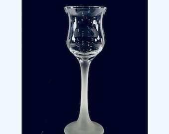 May include: A clear glass stemmed shot glass with a frosted finish. The glass has a wide bowl and a long, thin stem.