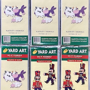 May include: Six packages of yard art patterns. The patterns include Nativity Animals and Nutcrackers. The packages are white with green and yellow accents. The patterns are easy-to-follow and include instructions. The packages are labeled with the pattern name, size, and pattern number.