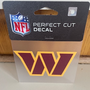 May include: A clear plastic sheet with a burgundy and gold "W" decal. The decal is a perfect cut NFL decal.