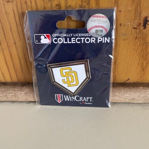 May include: A silver and gold San Diego Padres baseball team collector pin on a blue background with the text "Officially Licensed Collector Pin" and "WinCraft by Fanatics".