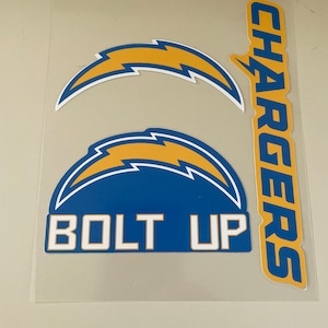 May include: A set of three Los Angeles Chargers decals. The decals feature the team's logo, a lightning bolt, and the words "CHARGERS" and "BOLT UP".