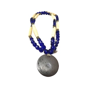 May include: A necklace with blue and white beads and a silver pendant with the number 860 on it.