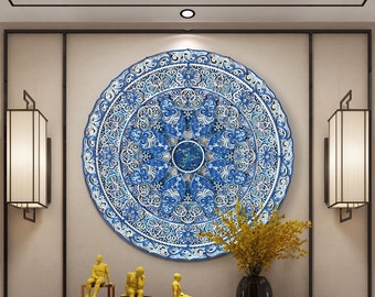 Può includere: Un grande decoro murale a forma di mandala blu e bianco con dettagli intricati. Il mandala è appeso a una parete con due lampade decorative su entrambi i lati. Ci sono tre piccole statue dorate su un tavolo di fronte al mandala.