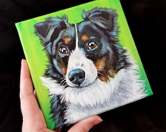 May include: A painting of a black and white border collie dog with brown markings on a green background. The dog is looking directly at the viewer. The painting is signed "Chea Taylor" in the bottom right corner.