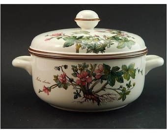 Peut inclure: Plat à gratin en céramique blanche avec un bord brun et un motif floral. Le couvercle a un bouton sur le dessus. Le plat porte l'inscription "Malva sylvestris" sur le côté.