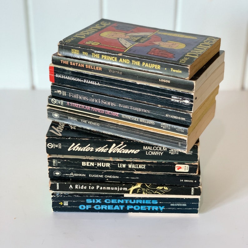 Pu&ograve; includere: Una pila di libri tascabili vintage con copertine nere e titoli colorati. Il libro in cima &egrave; rosso e presenta il titolo "Il principe e il povero" di Mark Twain. Il libro in fondo &egrave; nero e presenta il titolo "Sei secoli di grande poesia".