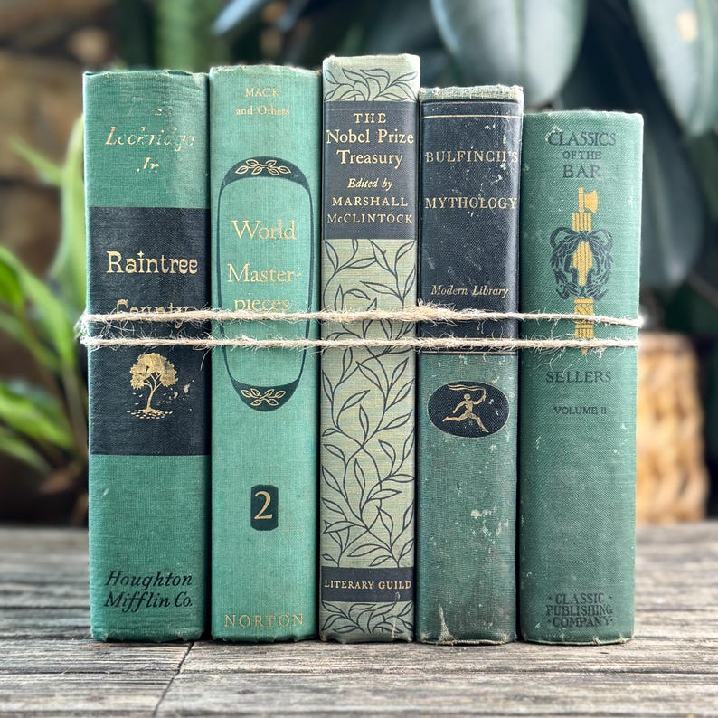 Puede incluir: Un conjunto de libros antiguos con cubiertas verdes y letras doradas, atados con cuerda. Los t&iacute;tulos incluyen "Raintree County" y "The Nobel Prize Treasury". Los libros presentan dise&ntilde;os decorativos y son de diferentes editoriales.