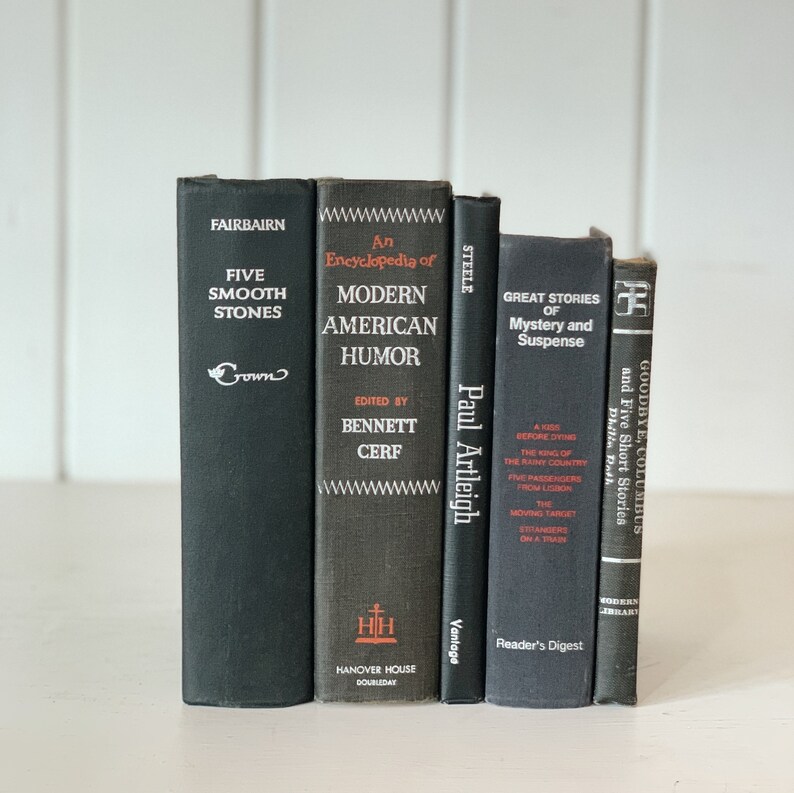 May include: A collection of five vintage books with dark covers. Titles include "Five Smooth Stones," "An Encyclopedia of Modern American Humor," and "Great Stories of Mystery and Suspense." The books are arranged vertically.