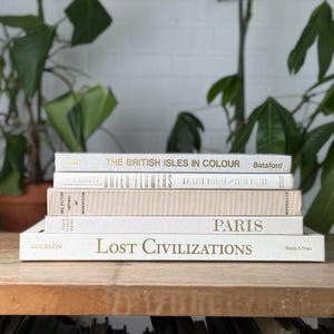 Pila de libros de mesa de centro vintage en tonos crema y blanco roto