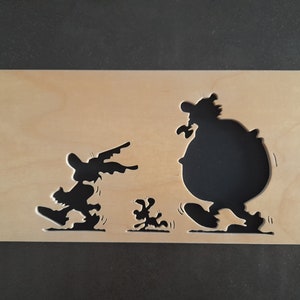 May include: Wooden plaque with a cartoon scene cut out. Three black silhouettes are visible: two figures and a small dog, all in motion. The light-coloured wood provides a contrast to the dark shapes, creating a dynamic image.