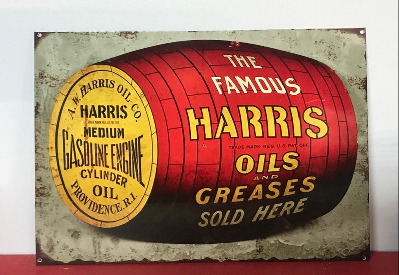 Peut inclure: Une enseigne m&eacute;tallique vintage publicitaire pour A.W. Harris Oil Co. avec un baril rouge et le texte "The Famous Harris Oils and Greases Sold Here" en lettres jaunes.