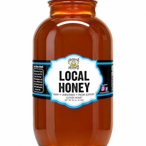 May include: A clear glass jar filled with amber-colored honey. The jar has a white lid and a label that reads "Heavenly Honey Local Honey." The label also states "Raw, Unfiltered, From Illinois, Clover Honey, Net Wt 80 oz (5 lbs)."