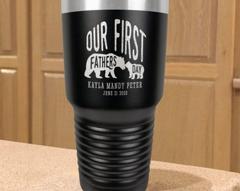 May include: Black stainless steel tumbler with a white design that says "Our First Fathers Day" with two bear silhouettes. The text below the bears says "Kayla Mandy Peter June 21 2020".