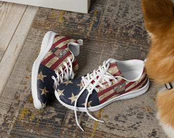 May include: Pair of sneakers with a patriotic design featuring the American flag. The shoes have a blue star-studded section, red and white stripes, and a white sole. The Texas State logo is visible on the side.