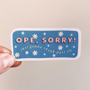 Puede incluir: Una pegatina azul con margaritas blancas y texto rosa que dice "OPE, SORRY! just gonna sneak past ya"