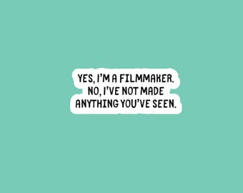 May include: A white sticker with black text on a light teal background. The text reads: "YES, I'M A FILMMAKER. NO, I'VE NOT MADE ANYTHING YOU'VE SEEN."