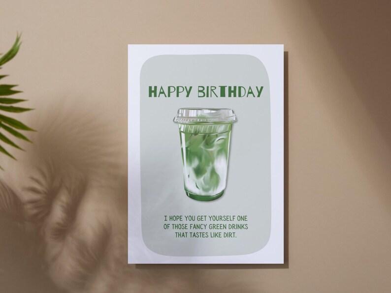 May include: A birthday greeting card with a green and white illustration of a green drink in a clear plastic cup. The text "HAPPY BIRTHDAY" is at the top, with a humorous message below.
