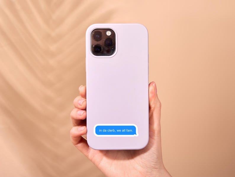 May include: A lavender phone case with a blue text message sticker that reads "in da cleb, we all fam."