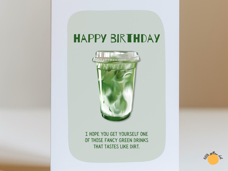 May include: A birthday greeting card with a green and white drink illustration. The words "HAPPY BIRTHDAY" are at the top, with the text "I HOPE YOU GET YOURSELF ONE OF THOSE FANCY GREEN DRINKS THAT TASTES LIKE DIRT." below the drink.