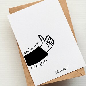 May include: A white greeting card with a black illustration of a hand giving a thumbs up. The card has the phrases "you're nice", "i like that", and "thanks!" written in black script. The card is inside a brown envelope.