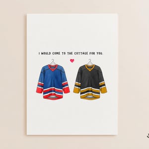 May include: Greeting card with the text "I would come to the cottage for you." Features illustrations of two hockey jerseys, one blue and red, the other black and gold, with a pink heart between them.