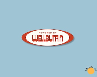 May include: A sticker featuring a red oval border on a light blue background. Inside the oval, the text reads POWERED BY WELLBUTRIN in a bold, retro-style font. In the bottom right corner, there is a small yellow circle with the text little yellow dot.