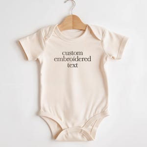 May include: A white ceramic mug with a black handle and the text "But First, Coffee" in a black, bold font. The mug is on a white surface. The mug is 4 inches tall.