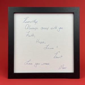 Black framed handwritten message addressed to Timothy and signed Mom, displayed against a red background.