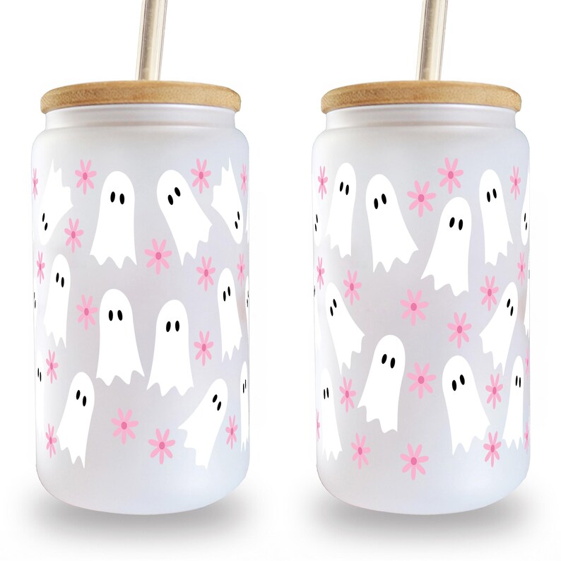 Two frosted glass can cups with white ghost and pink flower patterns, bamboo lids and straws on white.
