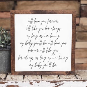 Brown framed sign with an affectionate handwritten style message, beside a succulent on a rustic shelf.