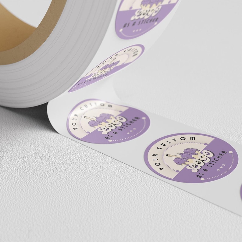 Roll of round purple-and-cream stickers printed with a sample custom-logo design, unspooled across a white surface.