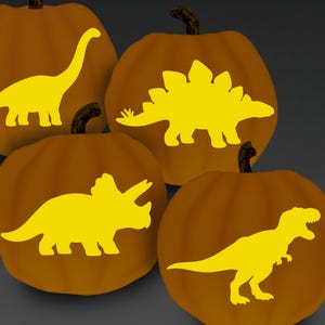May include: Four orange pumpkins with yellow dinosaur silhouettes. The dinosaurs include a Brontosaurus, Stegosaurus, Triceratops, and Tyrannosaurus Rex. The pumpkins have dark brown stems and are set against a dark gray background.