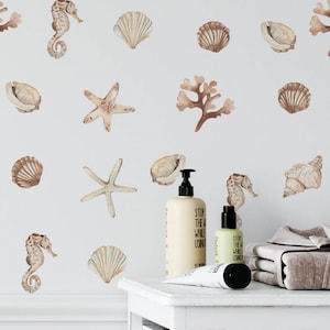 May include: A white bathroom with a white vanity and a wicker basket. The wall is decorated with brown and beige seahorse, starfish, and seashell decals. The vanity has two bottles of lotion and a tube of hand cream. The text on the bottles reads "Stop the world while using".