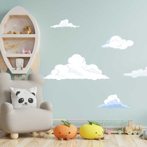 K&ouml;nnte beinhalten: Eine hellblaue Wand mit wei&szlig;en Wolken und einem wei&szlig;en Raketenregal mit Spielzeug darauf. Vor dem Regal steht ein grauer Sessel mit einem Pandakissen. Auf dem Boden liegen zwei orangefarbene und gelbe Spielzeuge in Form von Fr&uuml;chten.