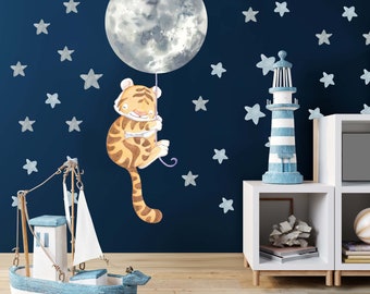 May include: A watercolor illustration of a tiger holding onto a moon balloon with a blue background and white stars.