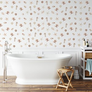 May include: A white bathtub with a white tiled wall behind it. The wall is decorated with a pattern of seashells, starfish, and coral in shades of brown and beige.