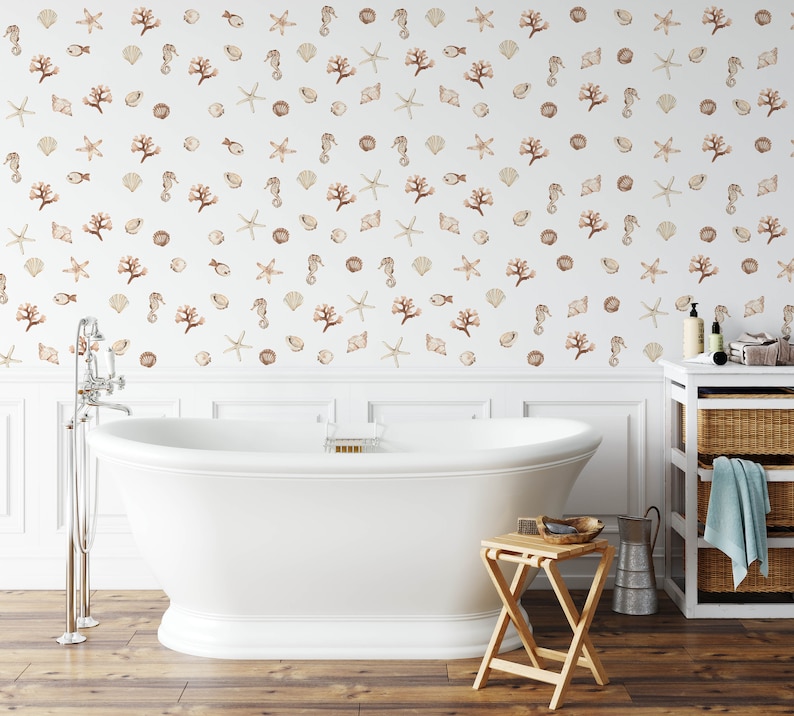 May include: A white bathtub with a white tiled wall behind it. The wall is decorated with a pattern of seashells, starfish, and coral in shades of brown and beige.